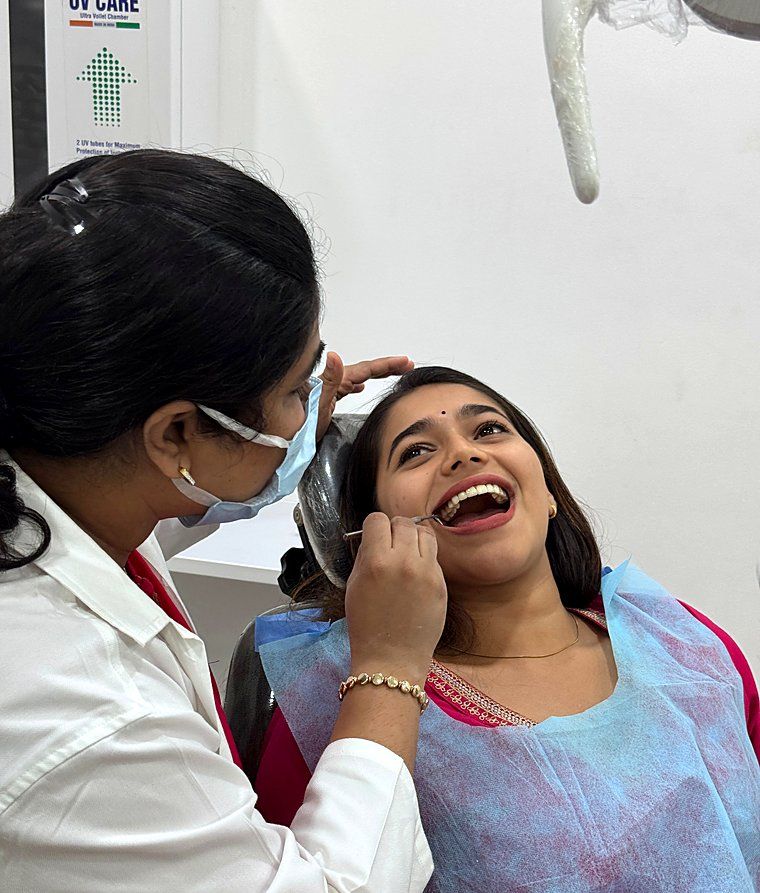 A dentist gently examining a smiling patient at Dr. Swati's Soul Dental